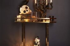 15 a glam Halloween bar cart with candles, lights, skulls, figurines and a bunting – just add some drinks and voila