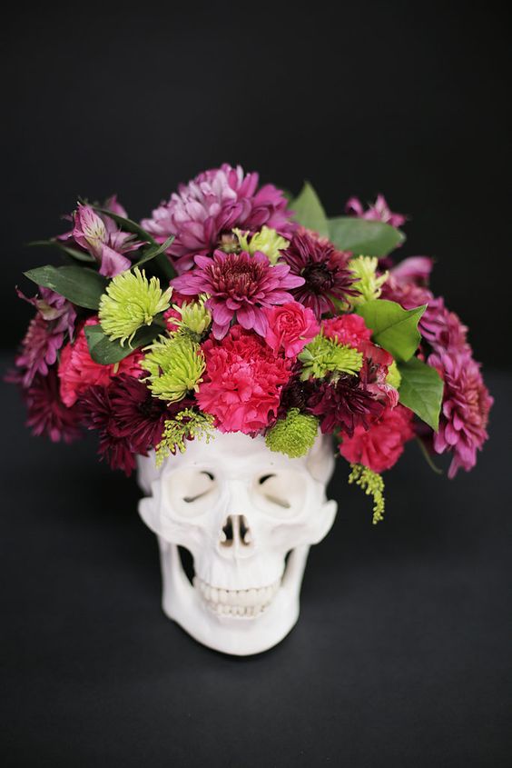 a skull with a bold flroal arrangement in pink, red and green plus some leaves is a timeless idea