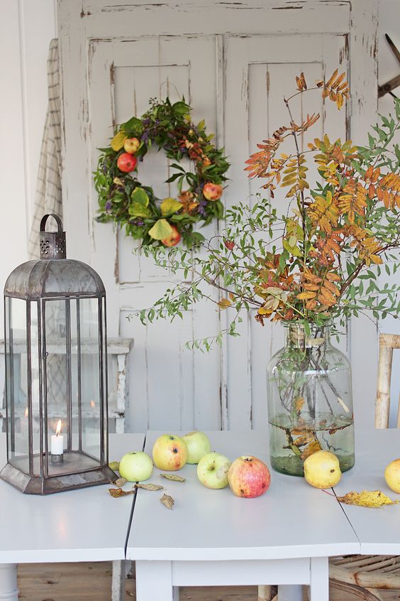 a fall leaf  arrangement, fresh apples, a greenery and apple wreath - all of these decorations are natural