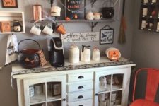 19 a Halloween drink station with jars, a cauldron, some spiderweb, candles and touches of orange and black