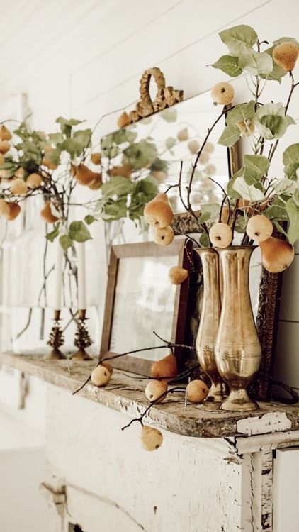 A fall mantel decorated with branches with fresh leaves and pears are amazing and non typical