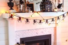20 a scary Halloween mantel with natural pumpkins, a spider bunting, lights, a house, some busts and branches with leaves