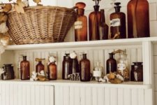 22 bathroom shelves with amber bottles, fall leaves, cotton and dried herbs will brign a fall spirit to the space