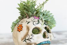 24 a sugar skull filled with grass and succulents is a cool and bright idea for a Day of The Dead party