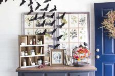 24 a vintage Halloween entryway with bats, a skull sign and a black cage with a faux blackbird create a mood here