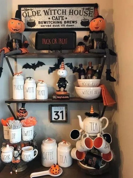 style your hot cocoa bar with black and orange mugs, bats, pumpkin figurines and signs to make it Halloween-like