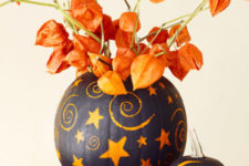 26 painted pumpkins with dried blooms that match will make up a bold and super catchy Halloween centerpiece