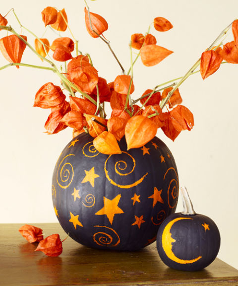 painted pumpkins with dried blooms that match will make up a bold and super catchy Halloween centerpiece