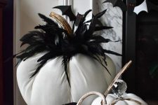 a black and white Halloween centerpiece of fabric pumpkins and feathers is a cool and long-lasting idea