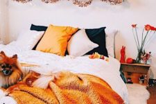 a bright Halloween bedroom with orange and black touches – bedding, letters, pumpkins and lanterns and even blooms