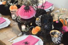 a bright modern Halloween centerpiece of a pink, black and orange fabric pumpkins and spiders is cool