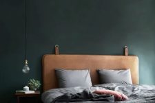 a brown leather headboard with metal rings brings a light industrial feel