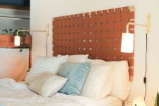 a mid-century modern bedroom with an amber leather headboard, blue and white bedding, nightstands and sconces