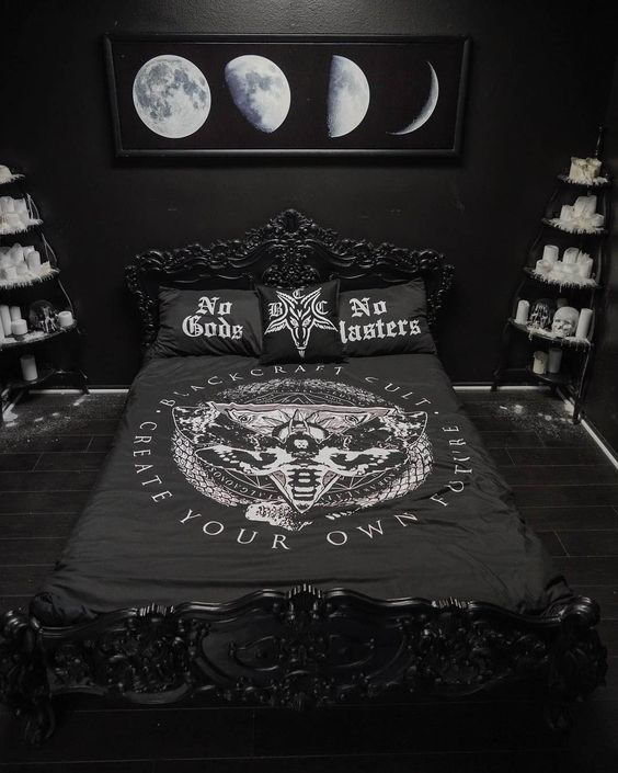 a moody Halloween bedroom in black is spruced up with some white touches - faux fur, candles, skulls and a moon artwork