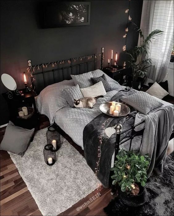 A mysterious artwork, some lights, candles in black candleholders and lanterns and moody textiles make the bedroom Halloween like