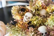 a neutral bowl with dried hydrangeas, skulls, lights and white velvet pumpkins for Halloween