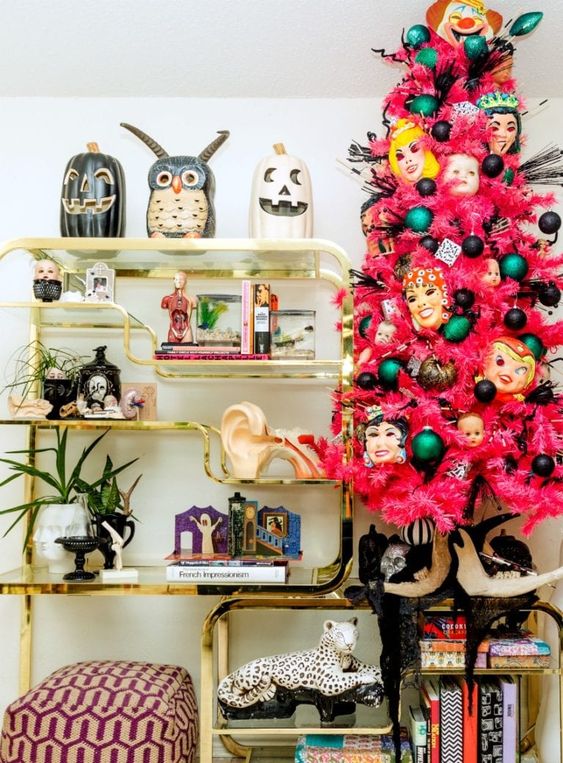a pink Halloween tree with black and green ornaments, masks and feathers is a bold and spooky statement for a party