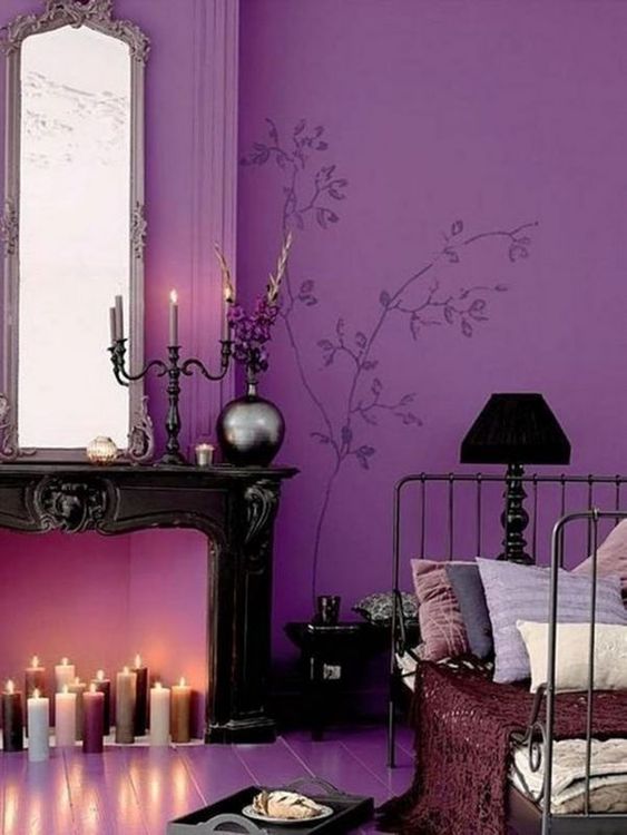 a refined Halloween bedroom with mauve and pastel candles, black lamps and a candelabra, dark bedding and a black bench