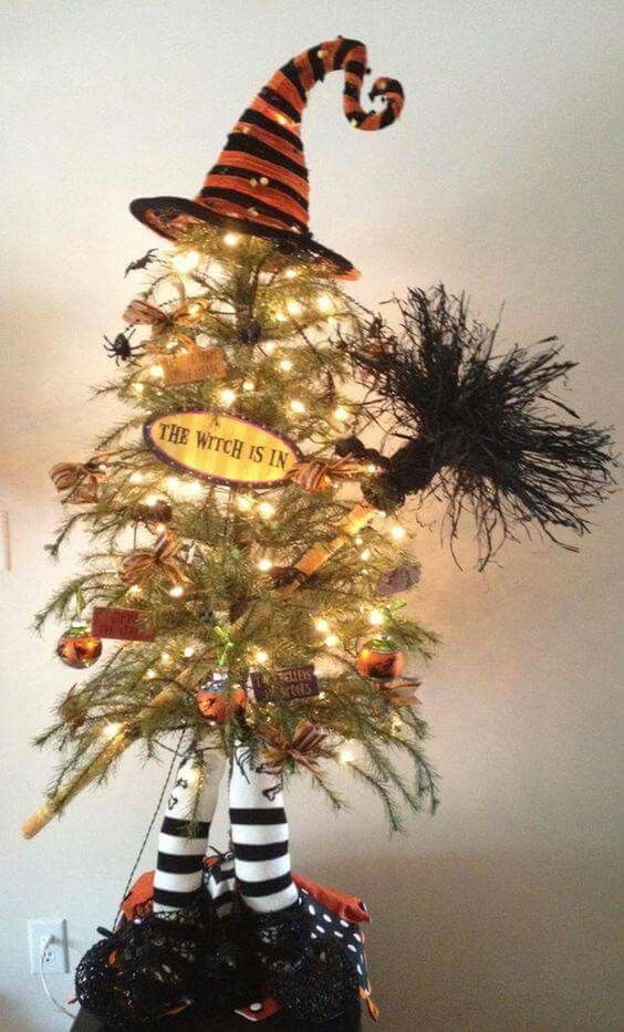 a small yet fun Halloween tree imitating a witch with legs, a hat and a broom decorated with ornaments and lights