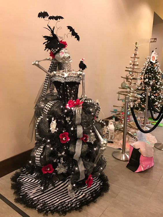 a unique Halloween tree of a silver skeleton, a black strapless dress, lights, banners, garlands and bats