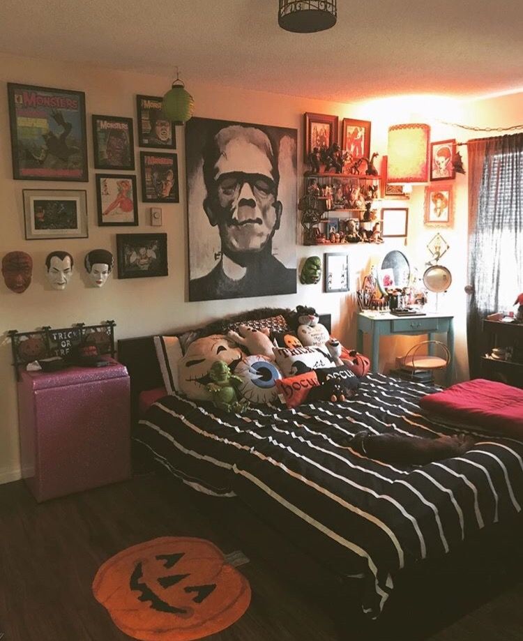 an arrangement of whimsy Halloween pillows, a scary gallery wall, a pumpkin rug and a striped bedspread