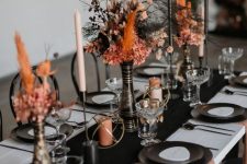 bright Halloween centerpieces of black and orange grasses, blooms and leaves are super chic and cool