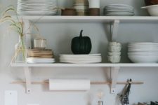 02 open minimalist shelves in the kitchen and a stick for hanging kitchen towels are a serene and cool kitchen