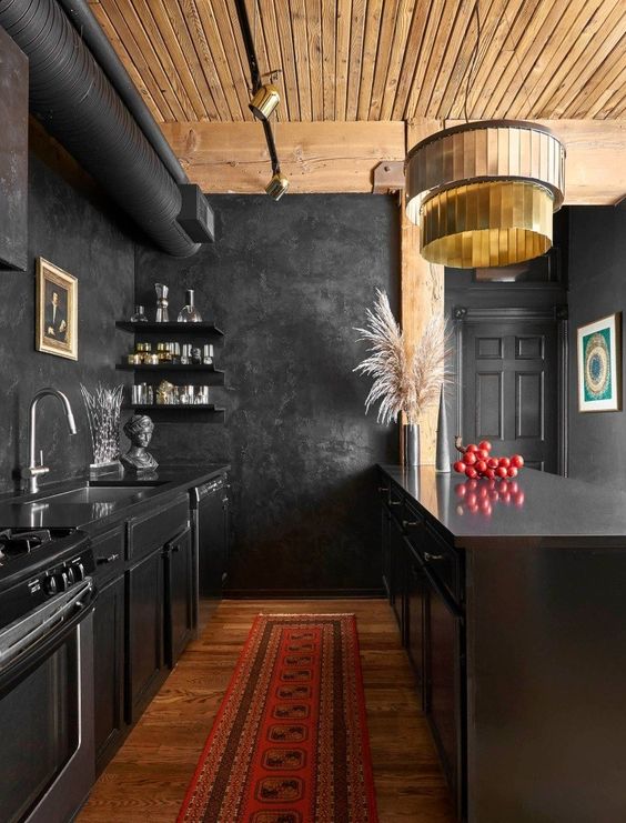 A creative vintage inspired kitchen in black with a light colored wooden ceiling and rich colored woodne floor to warm up the space