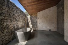 a stone bathroom design with a wooden roof
