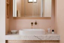 06 The bathroom is done in light peachy tones, with terrazzo and white marble