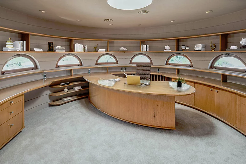 The home office is also circular, with arched windows, a curved desk and built-in shelves