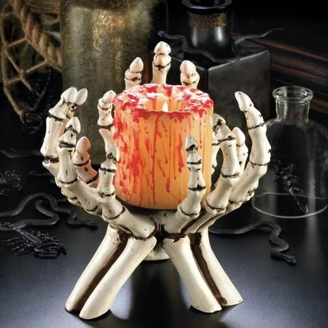 skeleton hands holding a bloody candle will be a nice decoration for a traditional Halloween party
