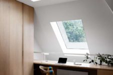 07 The home office features skylights and attic windows, a sleek storage unit and a large desk