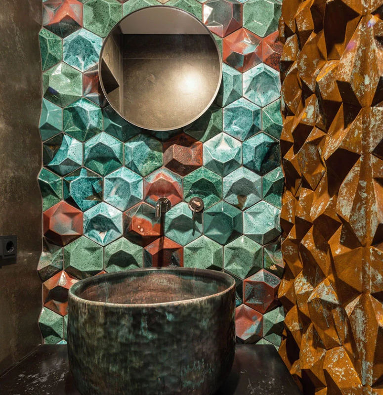 The bathroom is done with 3D porcelain tiles in rust, mustard and turquoise and a hammered metal sink