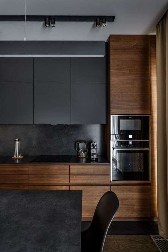 a dark black kitchen with sleek wooden cabinets that make it cozier and more welcoming