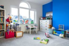 09 The kids’ room is bright and fun, with a statement blue wall, with colorful posters and lots of toys