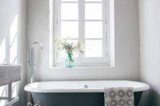 10 The bathroom is rustic, with a vintage tub, tiles, wooden beams and a large window