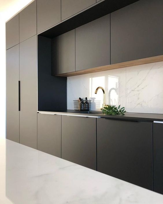 a minimalist black and white kitchen with a marble backsplash and a white floor looks bold and contrasting
