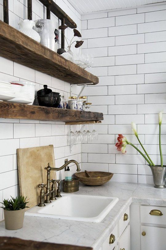 dark reclaimed wooden shelves look very bold and standing out in front of a white tile wall