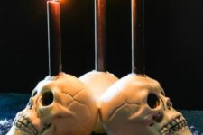 11 white skull candleholders with blakc candles are perfect for decorating your space for Halloween, simple and traditional
