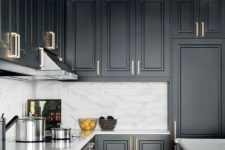 13 a black farmhouse kitchen refreshed wiith a white marble tile backsplash and metallic handles plus a sunburst lamp