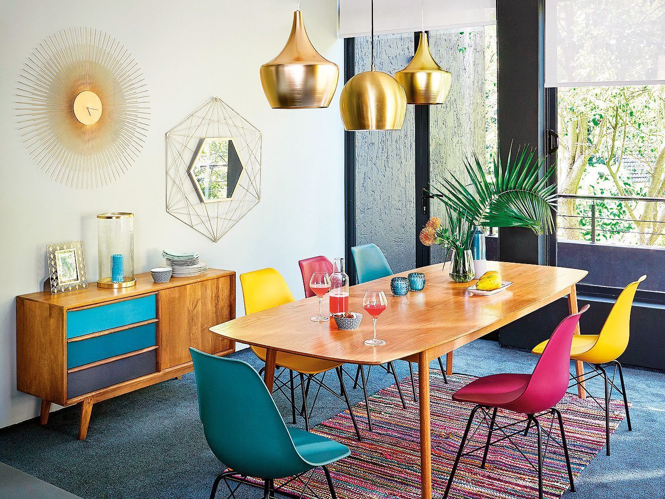 A bright mid century modenr dining space done with various shades of red, ble and metallics for a shiny touch