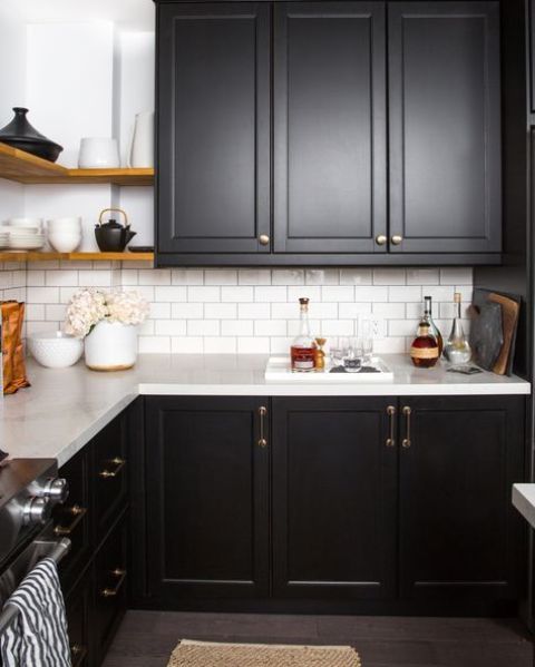 a black farmhouse kitchen refreshed with a white wall and a white subway tile backsplash for a contrasting look