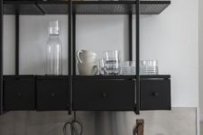 19 a black industrial shelving unit instead of upper cabinets is a stylish idea for a masculine and moody kitchen