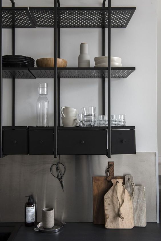 a black industrial shelving unit instead of upper cabinets is a stylish idea for a masculine and moody kitchen