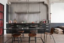 22 a black industrial kitchen made bolder with a concrete wall and metal countertops, handles and lamps