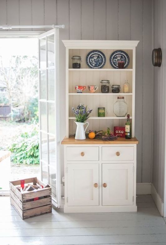 A small and cozy white buffet in the corner of your kitchen will give a nice farmhouse touch to the space