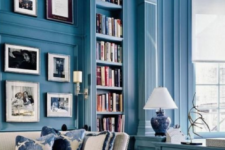 23 a bright blue home office and library with built-in bookshelves and elegant white furniture and artworks
