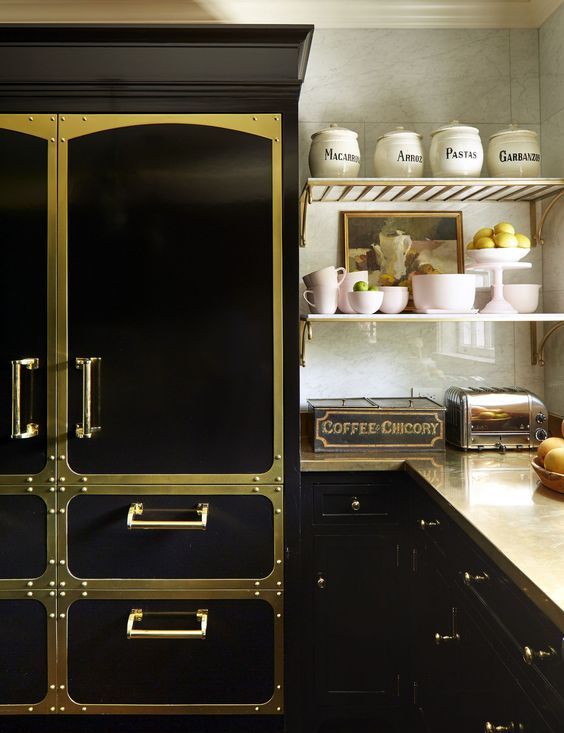 a creative and bold black kitchen spruced up with gold elements and matching metal countertops looks super glam