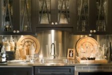 25 a vintage-inspired black kitchen with a metallic backsplash, coutnertops and appliances looks very bold